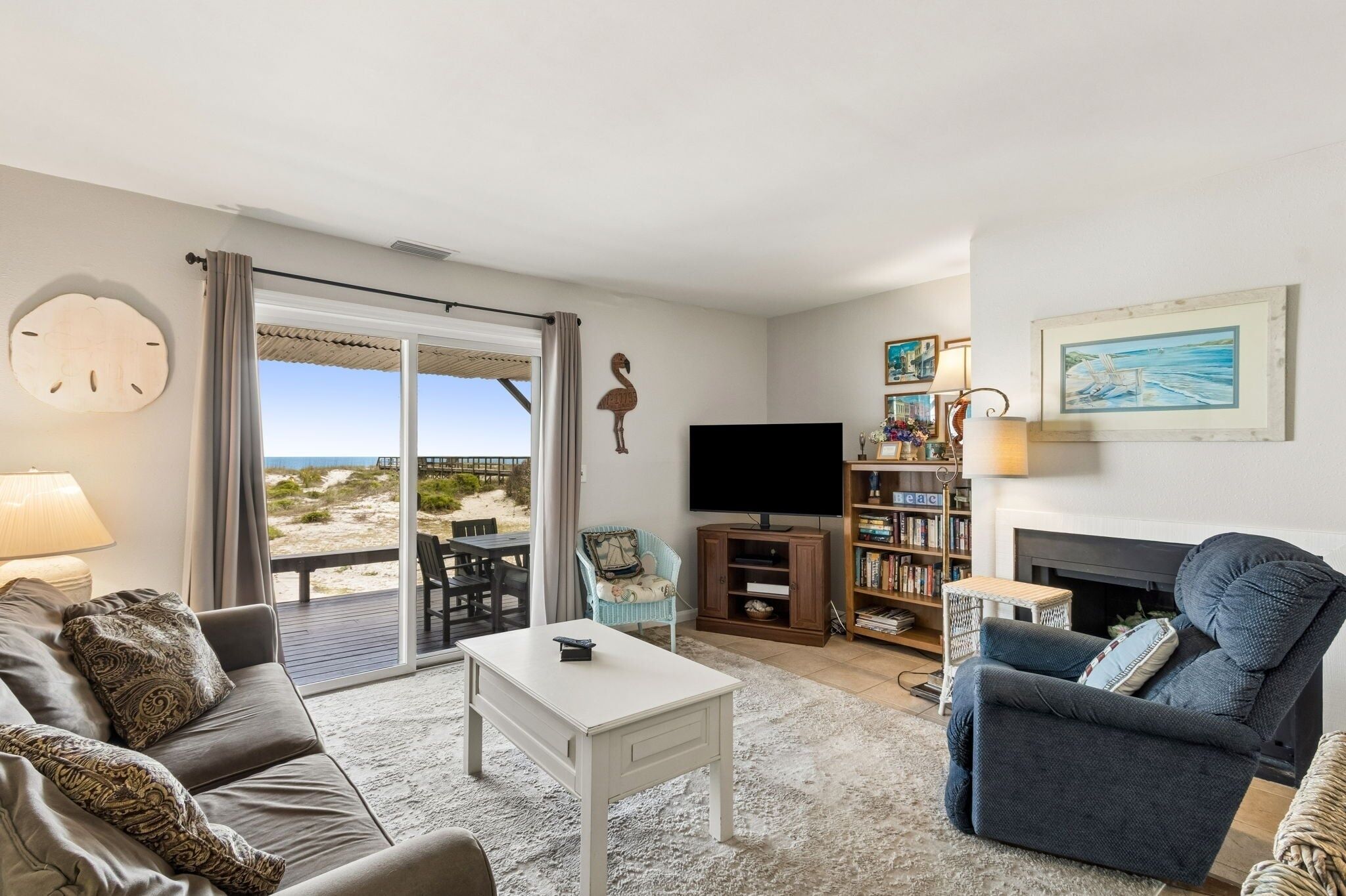 A living room with a sofa, a coffee table, a TV, a bookshelf, and a fireplace.