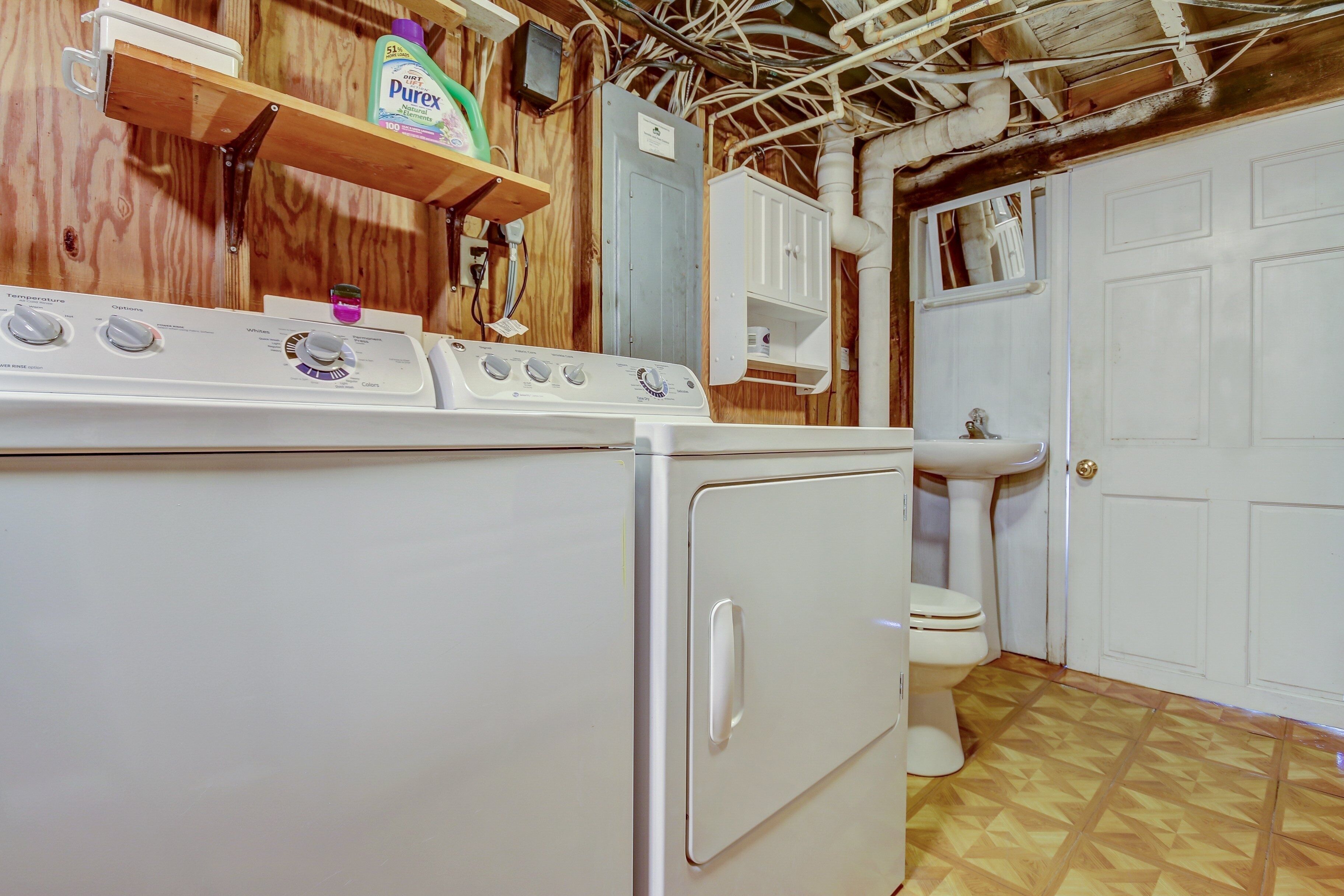 A compact laundry room with a washing machine, dryer, and sink.
