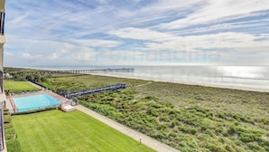 A beachfront property with a swimming pool, a pier, and a view of the ocean. - Breathtaking Ocean View Amelia South Condo by RedAwning (Fernandina Beach)