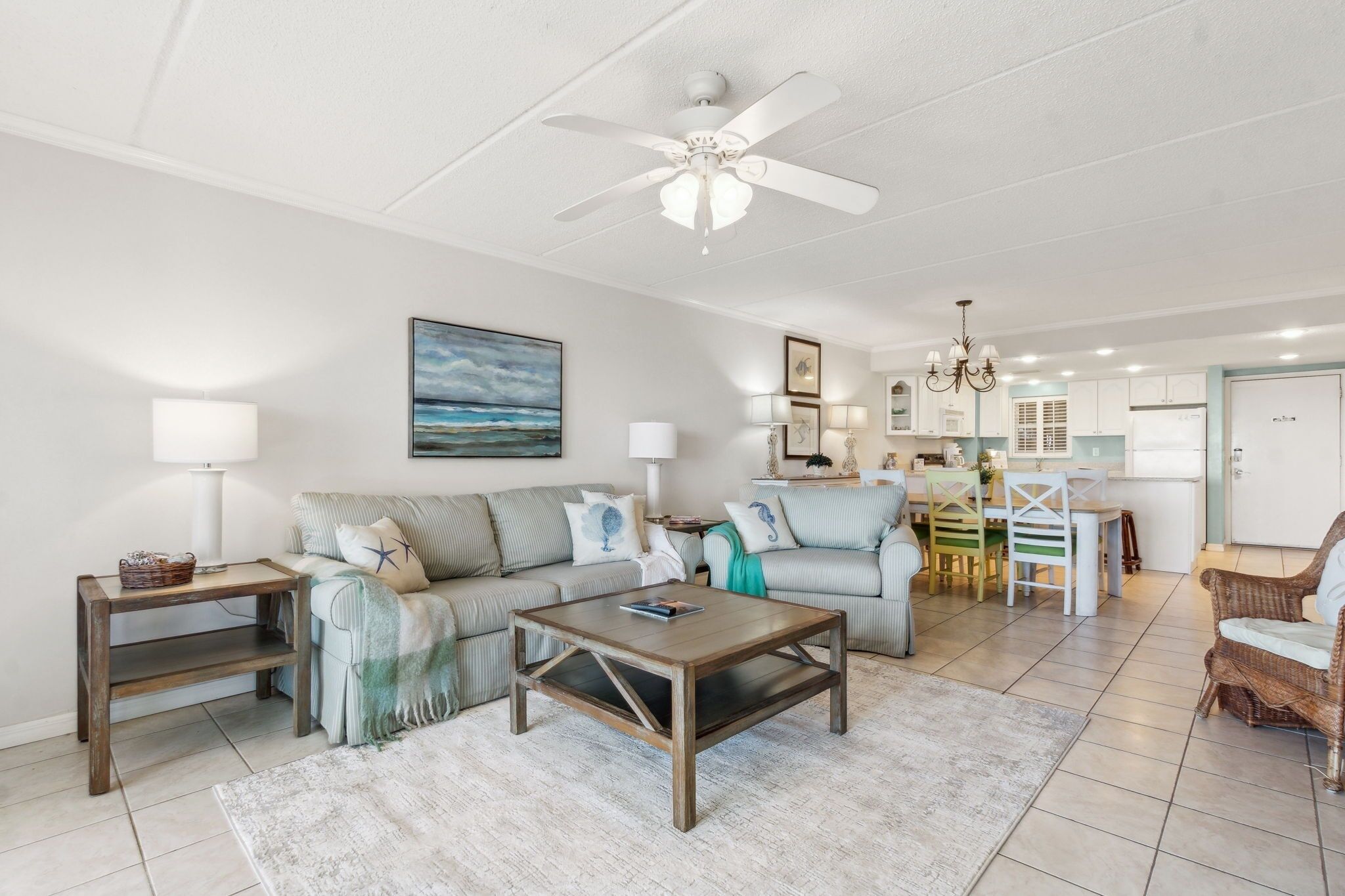 A spacious living room with a large sofa, coffee table, and dining area.