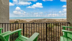 A balcony with a view of a beach and dunes. - Modern Condo with Amazing Ocean Front Views by RedAwning (Fernandina Beach)