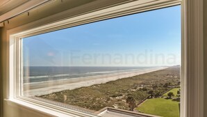 A view from a window overlooking a beach with a clear sky. - Amelia South B7 by RedAwning (Fernandina Beach)