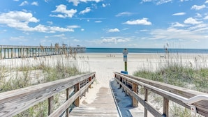 A wooden boardwalk leading to a beach with a clear sky and clouds. - Upper unit Overlooking the Beautiful Outdoor Space and Pier by RedAwning (Fernandina Beach)