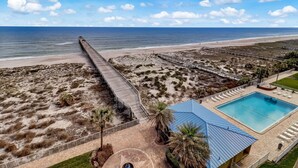 A beachside resort with a long pier, a swimming pool, and a boardwalk. - Oceanfront Condo with Beach Access, Pool, and Tennis Court by RedAwning (Fernandina Beach)