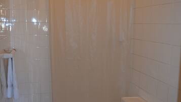 Un baño con inodoro, ducha y lavamanos.