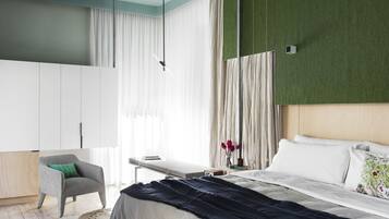 Un dormitorio moderno con cama, sillón, mesita de noche y armario.