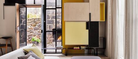 A modern living room with a sofa, a coffee table, and a fireplace.