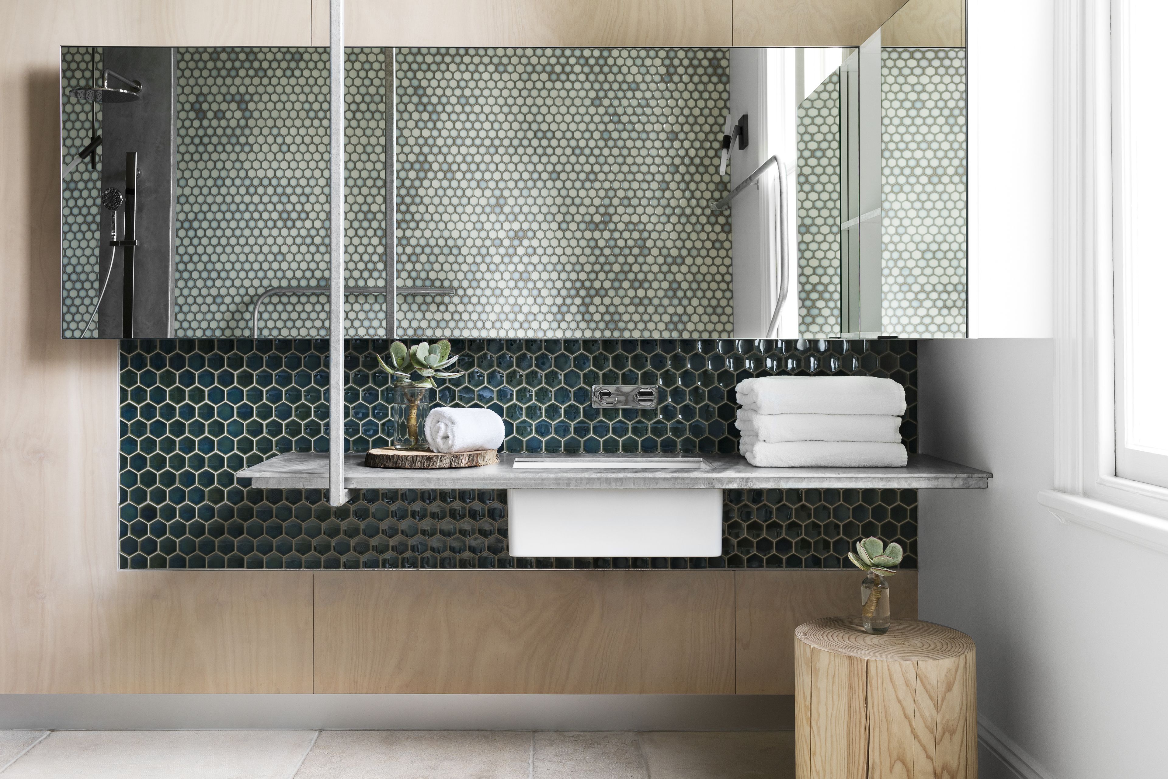 Un baño moderno con tocador de madera, lavabo, espejo y ducha.