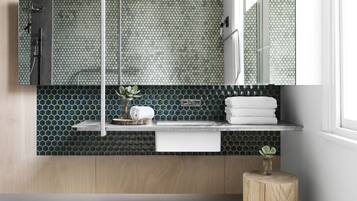 Un baño moderno con tocador de madera, lavabo, espejo y ducha.