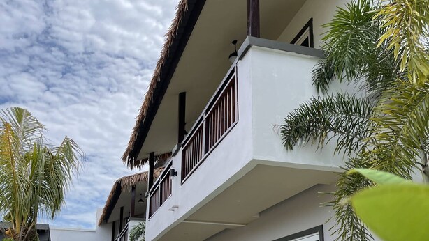 A multi-story building with balconies, surrounded by tropical plants and a clear sky. - Lavigo Resort (Langkawi)