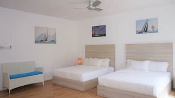 A bedroom with two beds, a sofa, and a ceiling fan.