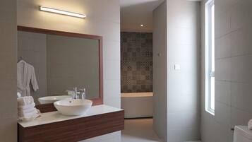 A modern bathroom with a large mirror, two sinks, and a shower area.