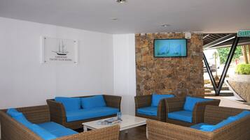 Eine Lounge mit Korbmöbeln und einer Steinwand.