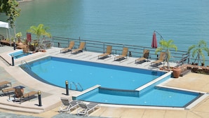 Ein Pool mit Liegestühlen und Blick auf das Wasser.