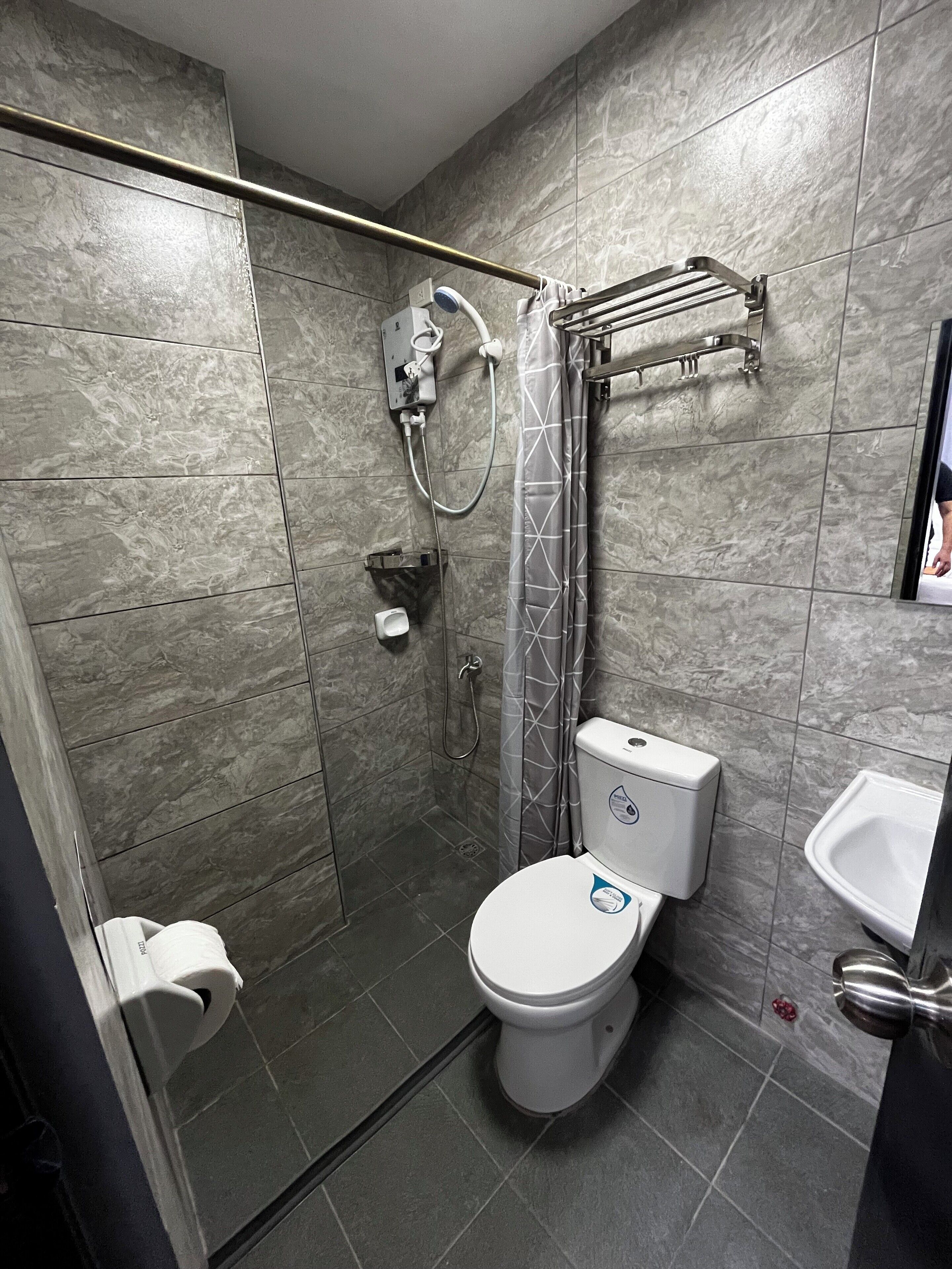 Een moderne badkamer met een inloopdouche, toilet en wastafel.