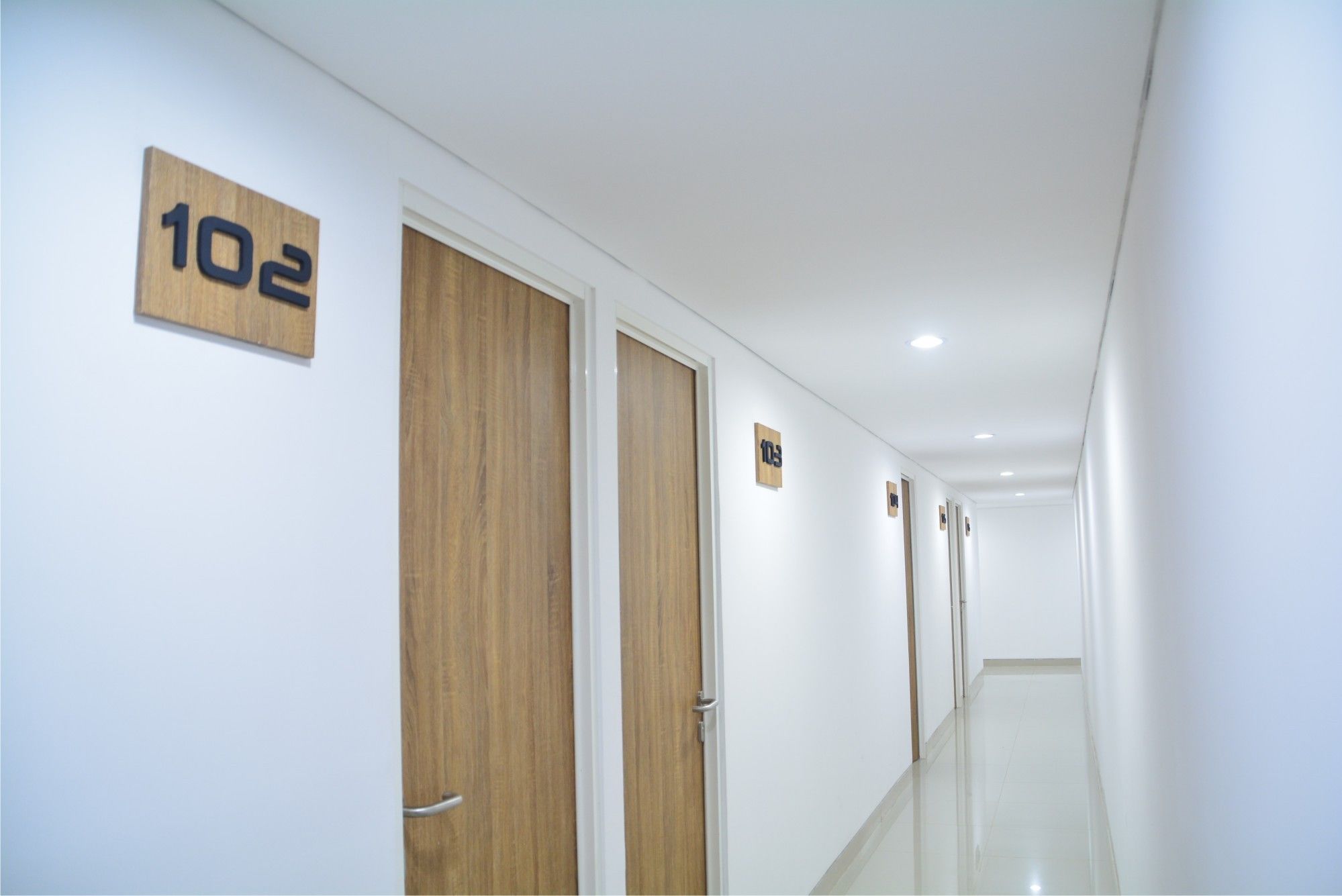 A hallway with wooden doors numbered 102 and 103.