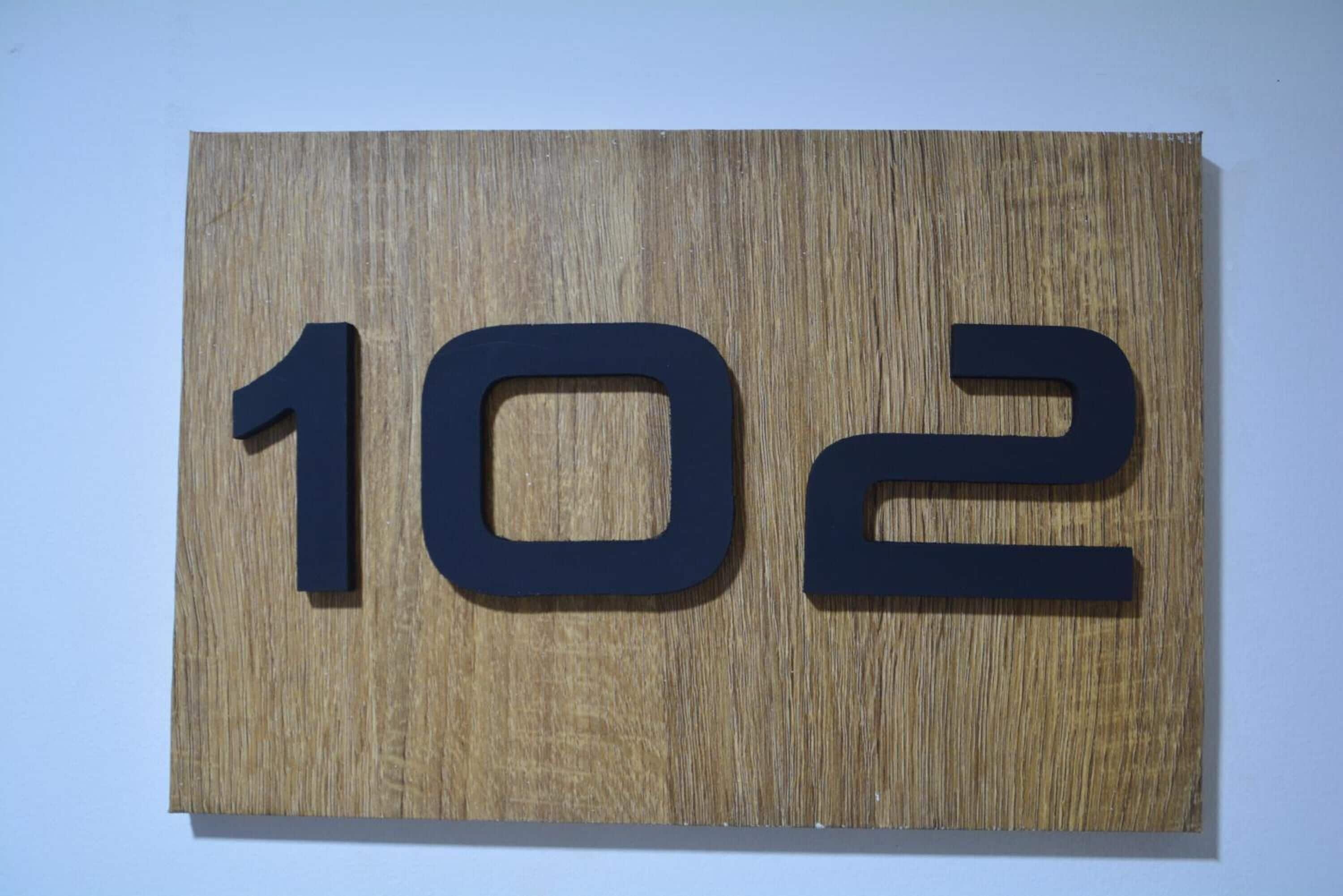 Un letrero de madera con el número 102.