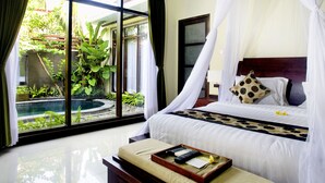 Une chambre à coucher comprenant un lit, une table de chevet, une fenêtre et donnant sur un jardin et une piscine.