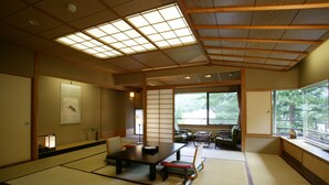 A traditional Japanese room with tatami flooring, a low table, and sliding doors. - Sekizenkan (Nakanojo)