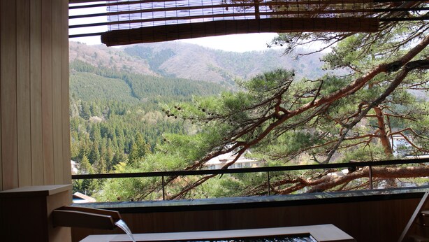 A wooden interior with a view of a forested valley through a window. - Sekizenkan (Nakanojo)