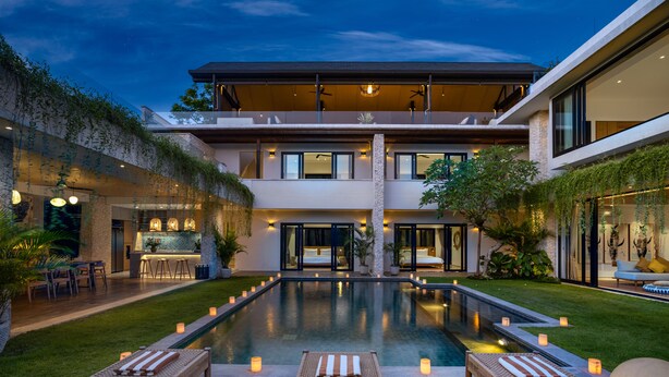 Una casa moderna con piscina, mobiliario exterior y zona de bar.
