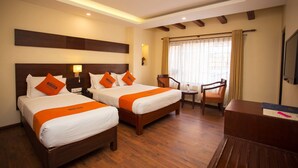 A hotel room with two beds, wooden flooring, a desk, and a chair. - Hotel Jay Suites (Kathmandu)