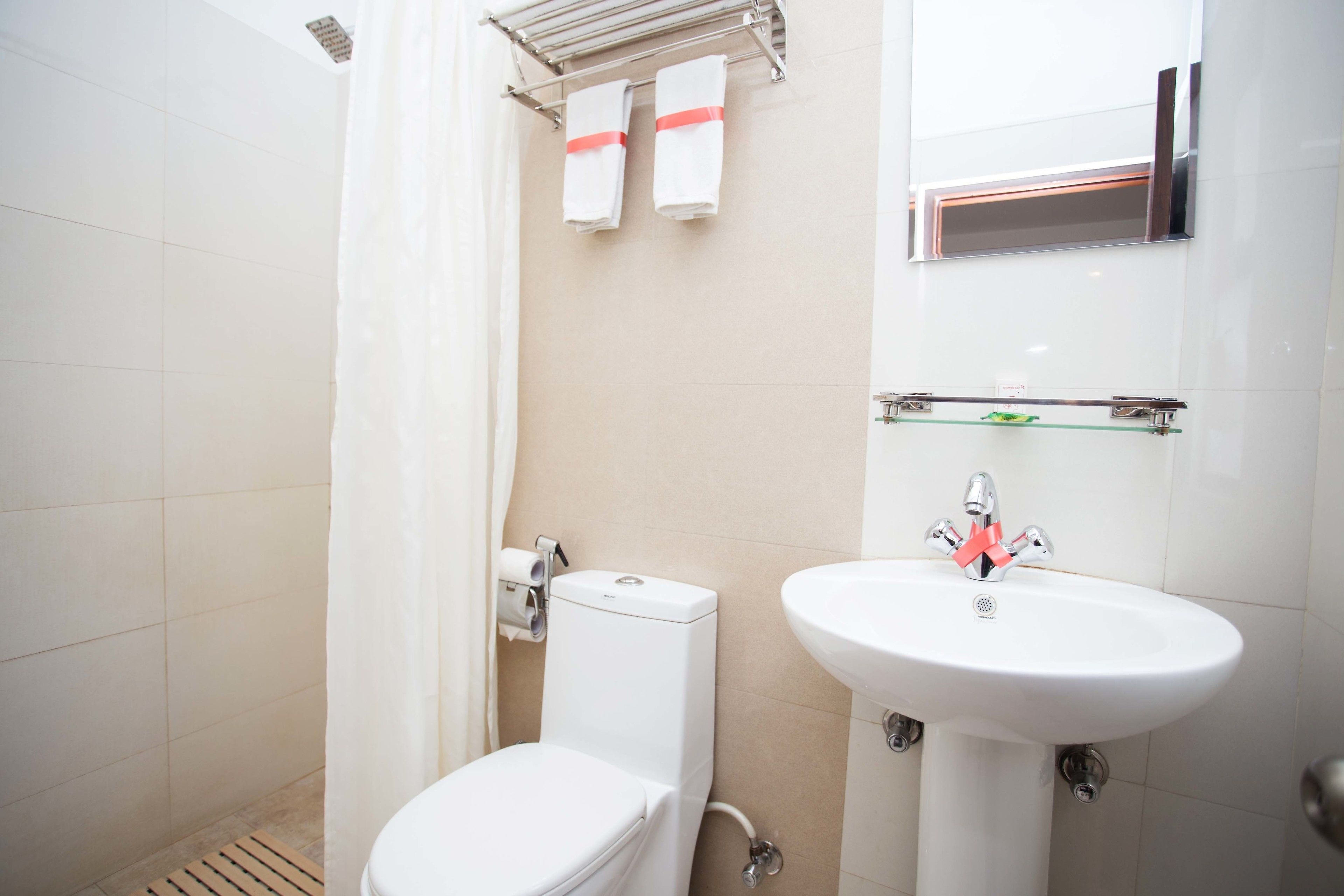 A bathroom with a toilet, a sink, and a shower curtain.