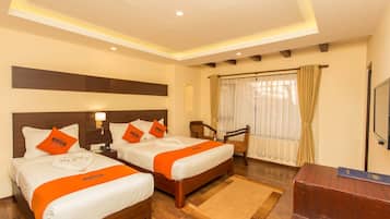A hotel room with two beds, a desk, and a chair.