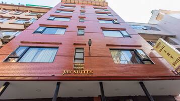 Un hôtel appelé « Jay Suites », avec une façade en briques rouges, de nombreuses fenêtres et une enseigne indiquant qu’il propose des suites.