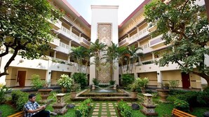 A courtyard with a central fountain, surrounded by potted plants and benches. - Puri KIIC Golf View Hotel (Karawang)