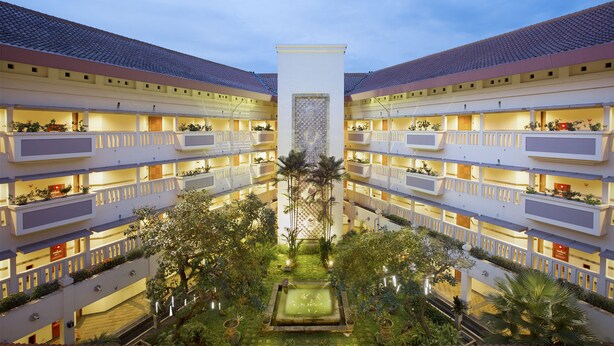 A multi-story hotel with balconies, a central courtyard, and a pool. - Puri KIIC Golf View Hotel (Karawang)