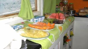 A buffet table with various food items and condiments. - Noronha Sol e Mar Pousada (Fernando de Noronha)