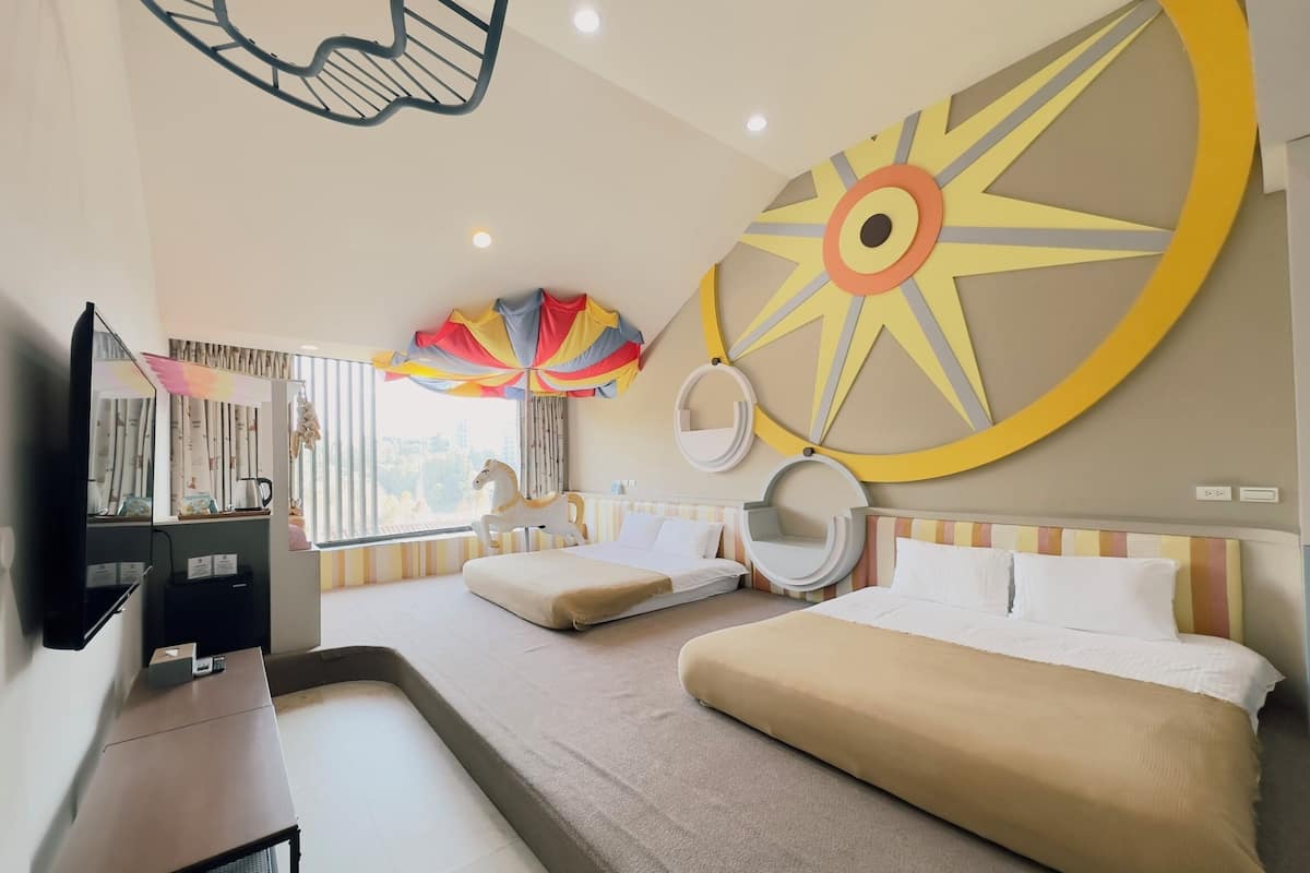 A modern hotel room with a large bed, a desk, a television, and a decorative wall piece.