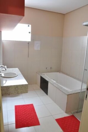 Bathroom features a sink and bathtub, with a window above.