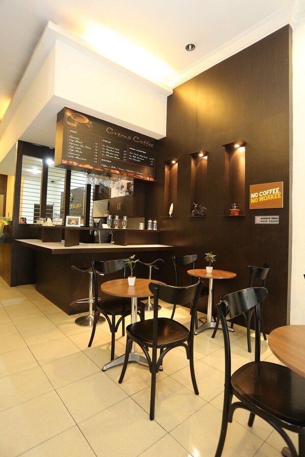 A modern coffee shop interior with a counter, menu, and seating area.