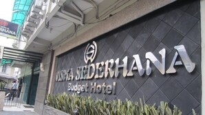 Een bordje voor Hotel Vista Sederhana Budget, met een modern ontwerp en een logo.