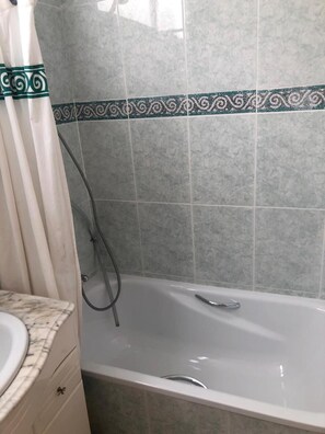 A bathroom with a bathtub, a shower, and a vanity with a sink. - SI Rooms Puerta del Sol (Castelló de la Plana)