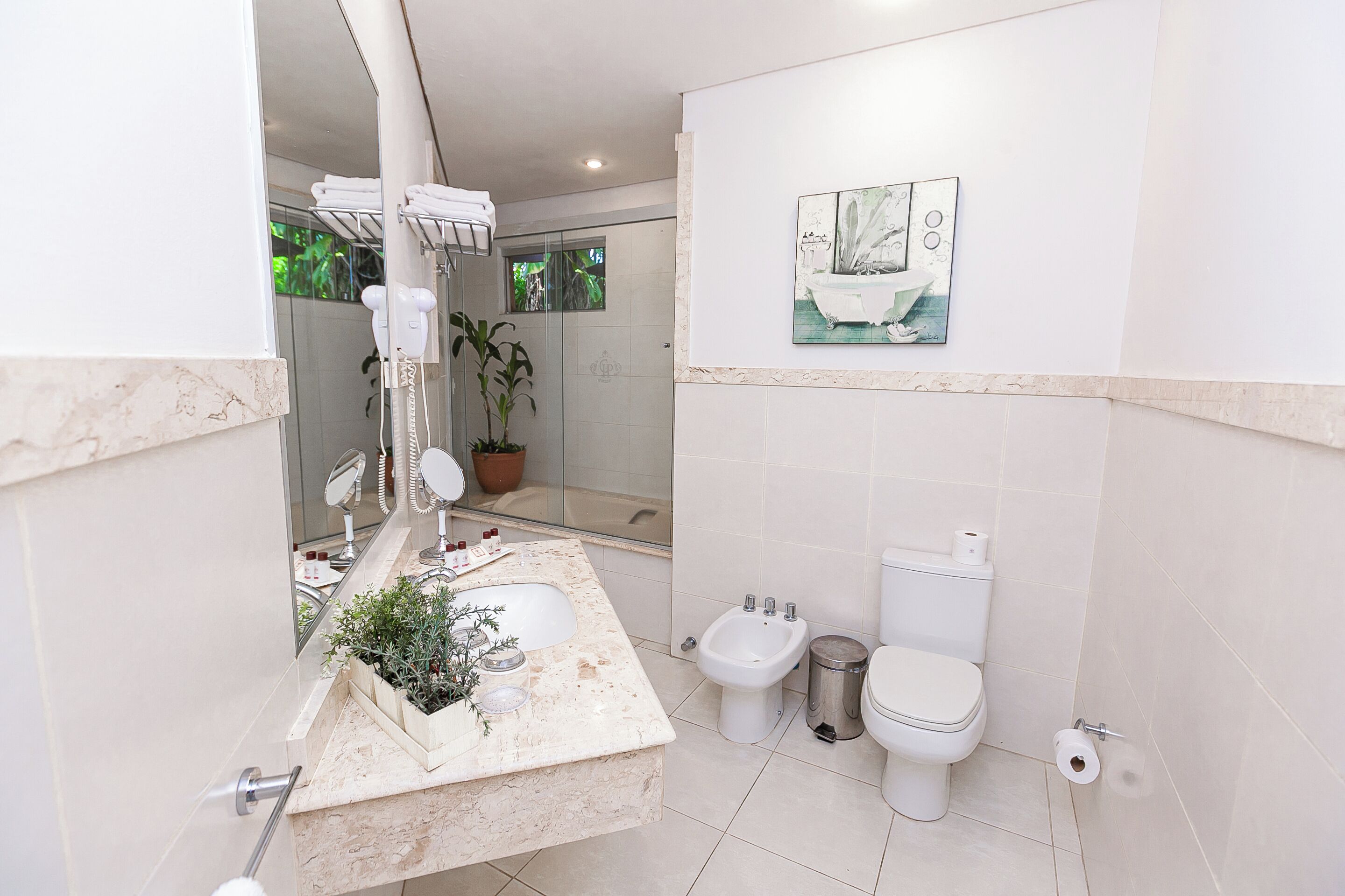Une salle de bain moderne avec un lavabo en marbre, un bidet, des toilettes et un espace douche.