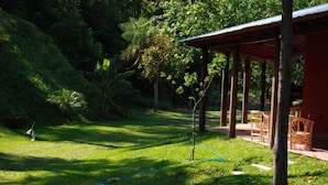 A covered outdoor area with a wooden structure, surrounded by lush greenery and trees. - Rio Arriba Suites Apartments y Resto (Bella Vista)