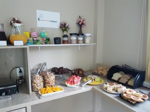 A breakfast buffet with various food items, including fruits, pastries, and condiments. - Hotel Pousada Cabana Da Mata (Gramado)