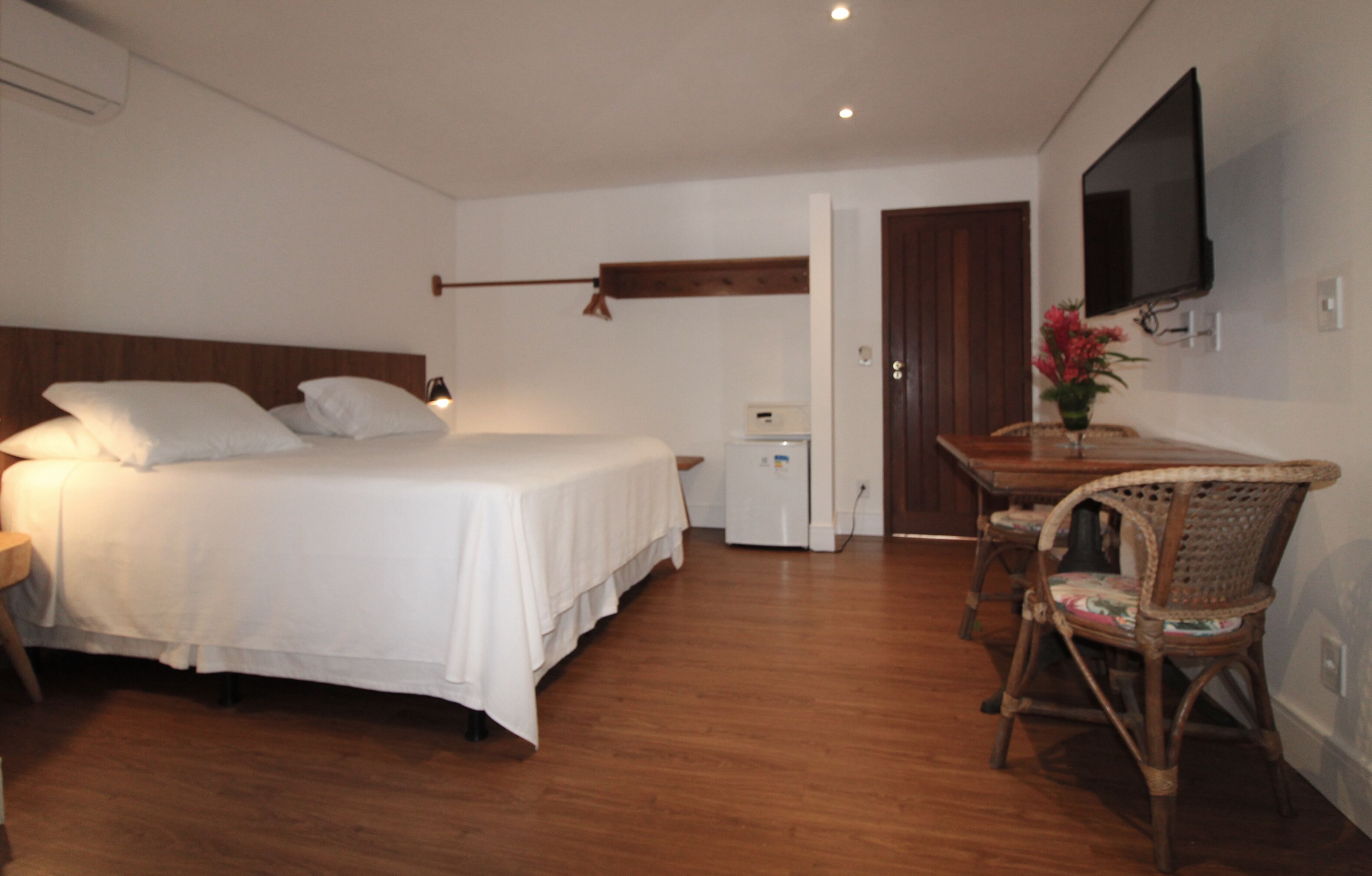 A bedroom with a bed, bedside table, and a small desk with a chair.