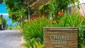 Une enseigne en bois portant les inscriptions « CHEIRO VERDE » et « POSADA », indiquant le nom d’un établissement.