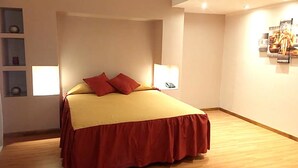 A neatly arranged bedroom with a bed, two bedside lamps, and a wall-mounted artwork. - Hotel Aoma Mar del Plata (Mar del Plata)