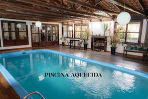 Una piscina con cubierta de madera y techo rústico.