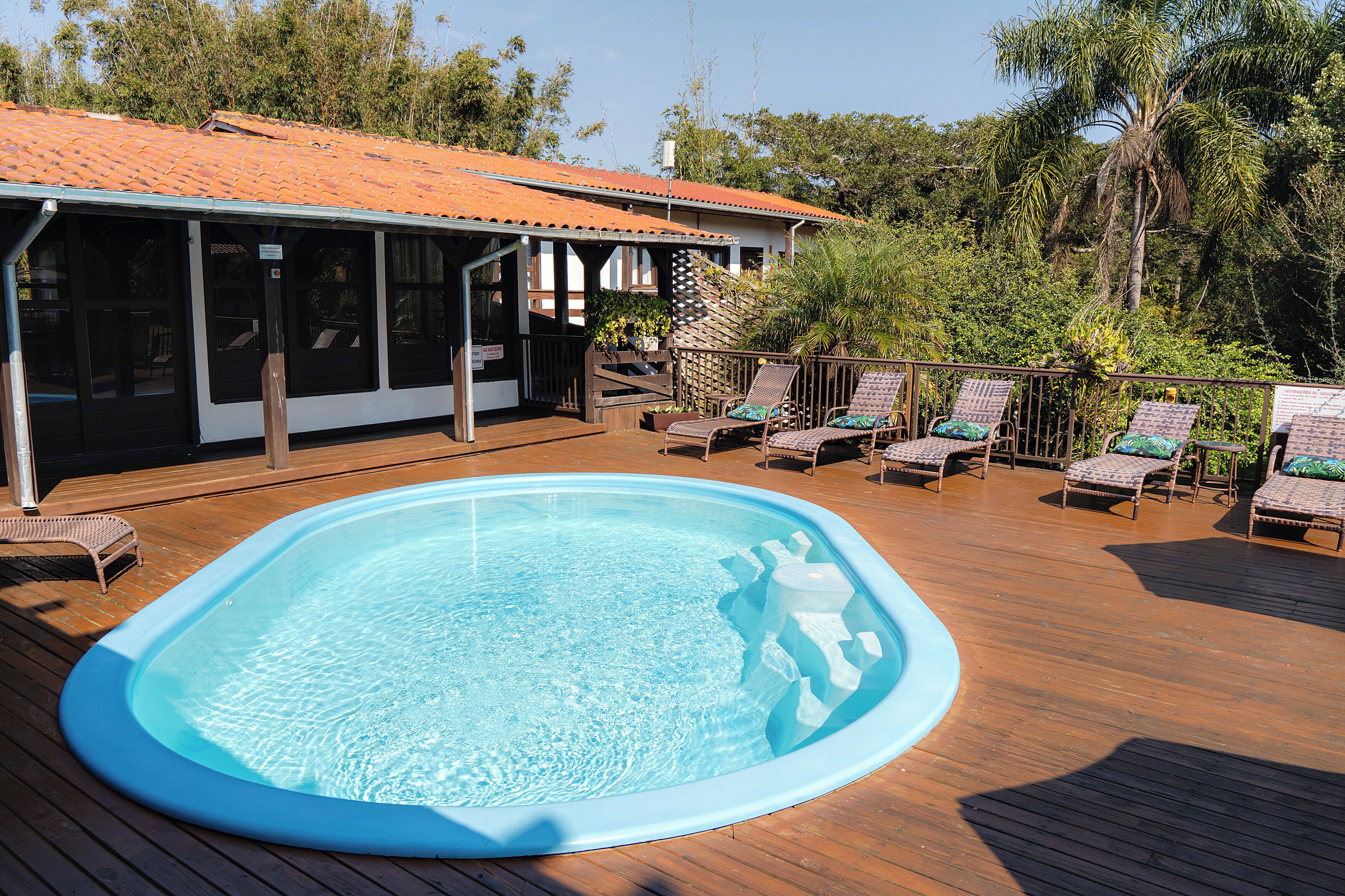 A swimming pool with lounge chairs and a covered deck area.