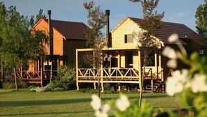 A rustic wooden house with a red roof, surrounded by a wooden fence and greenery. - Paso del Tigre (Santa Fe)