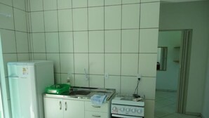 A compact kitchen with a refrigerator, stove, and sink. - Residencial Floripamar 2 (Florianópolis)