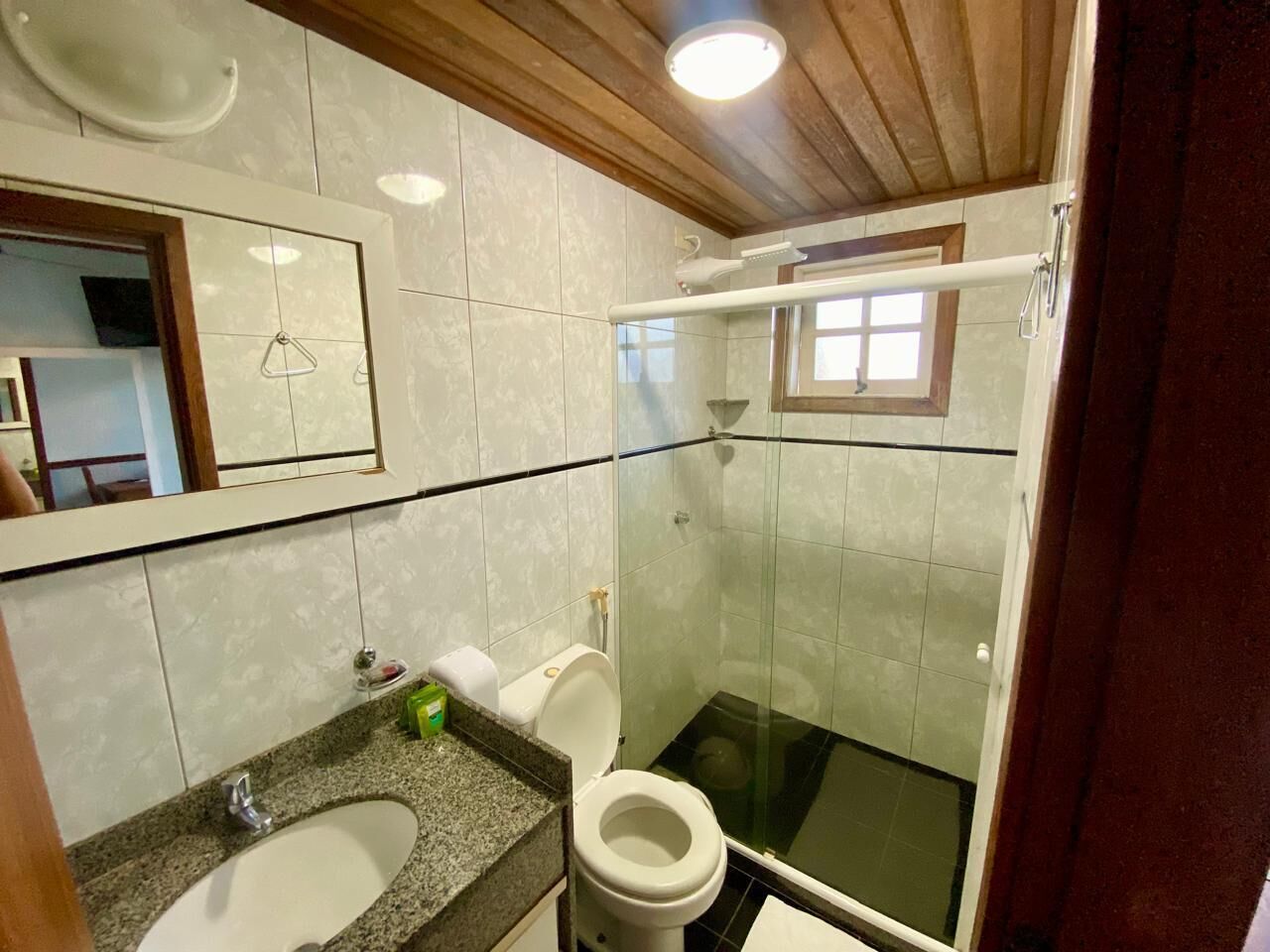 A bathroom with a sink, toilet, and glass-enclosed shower.