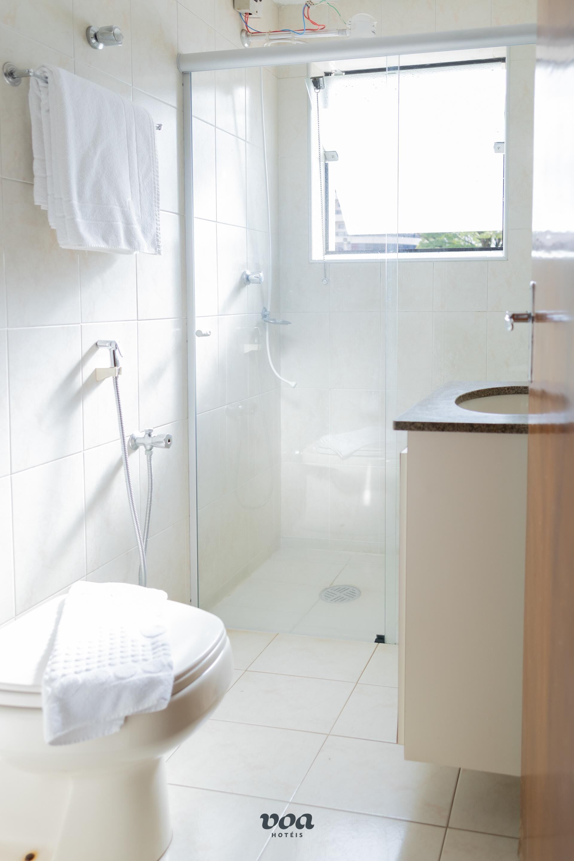 Une salle de bain avec des toilettes, une douche et un lavabo.