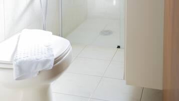 Une salle de bain avec des toilettes, une douche et un lavabo.